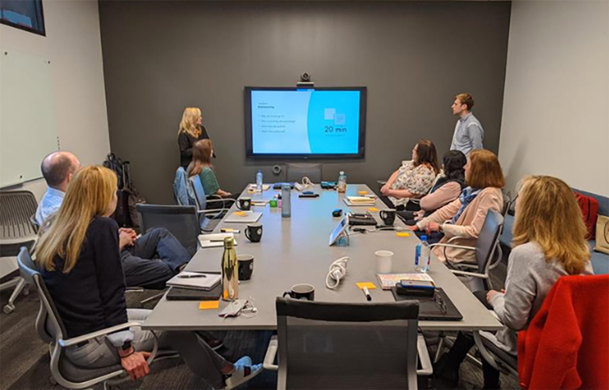 Team gathered around a screen during a presentation